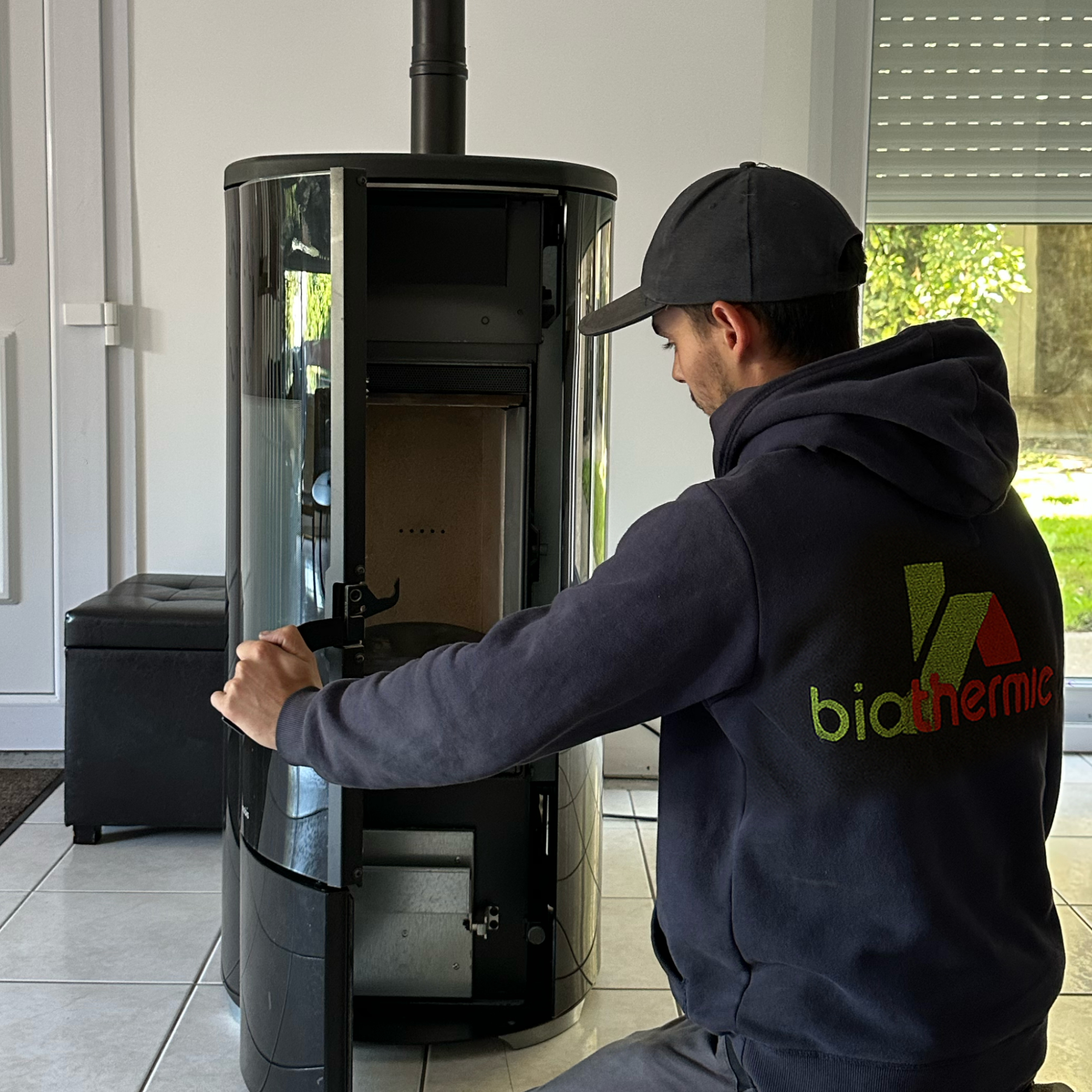 Technicien Biothermic effectuant l'entretien d'un poêle